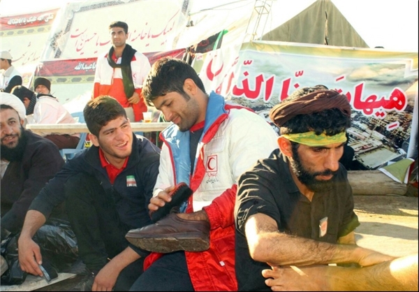(تصویر) قهرمان کشتی در حال واکس‌زدن کفش زائران حسینی
