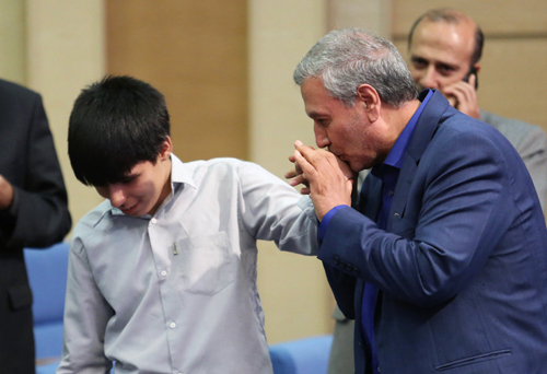 (تصاویر) بوسه وزیرکار بر دست مددجوی نوجوان