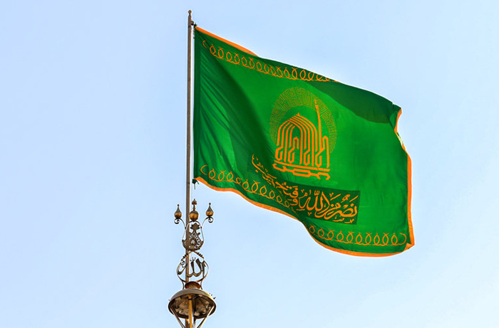 (تصاویر) تعویض پرچم گنبد امام رضا(ع)