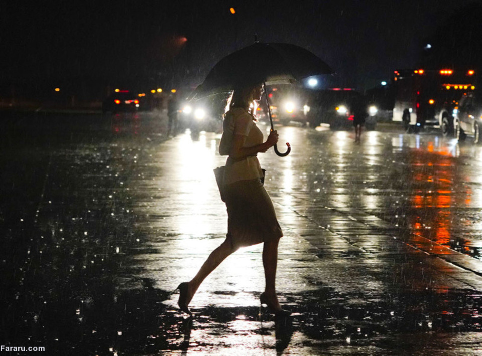 ایوانکا ترامپ، مشاور و دختر رئیس جمهور آمریکا با چتر و در زیر باران در پایگاه هوایی اندروز در ایالت مریلند.