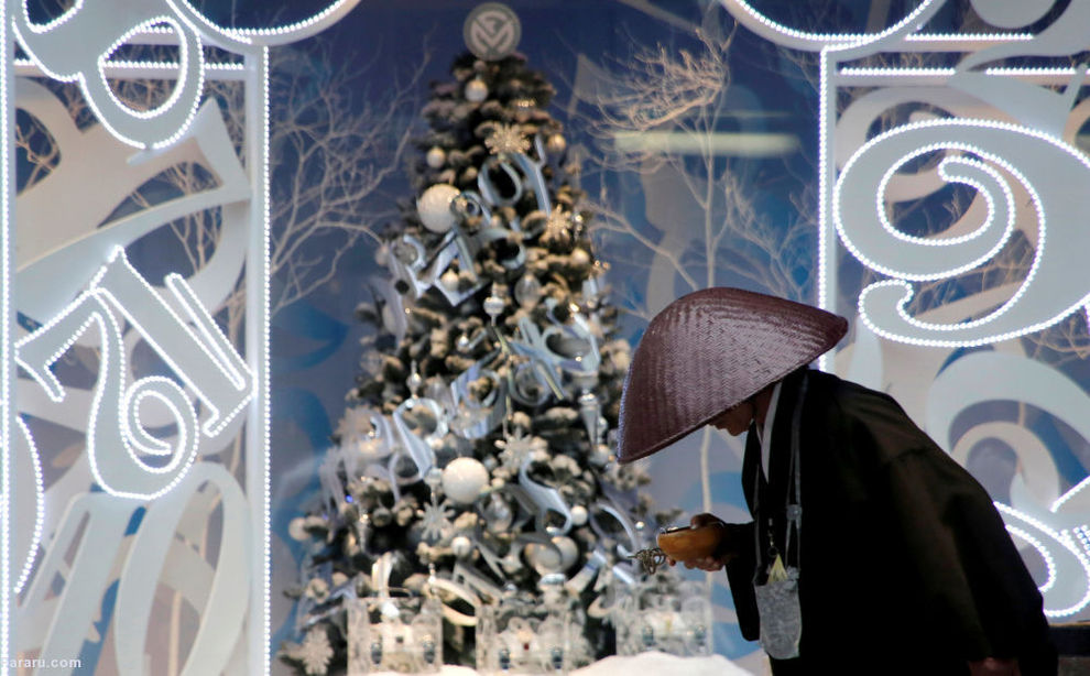 راهب بودایی در مقابل درخت کریسمس در توکیو