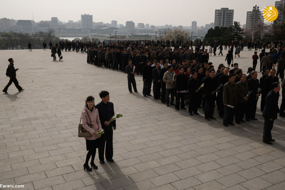 نثار گل به پای مجسمه رهبر کره شمالی در پیونگ یانگ در زمان جشن خورشید