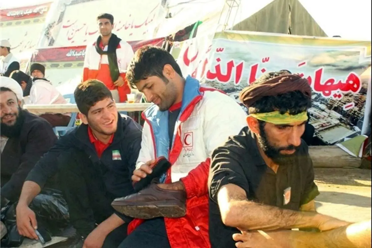(تصویر) قهرمان کشتی در حال واکسزدن کفش زائران حسینی
