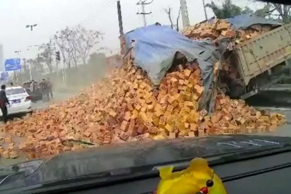 (ویدئو) فروریختن آجرهای یک کامیون روی خودرو