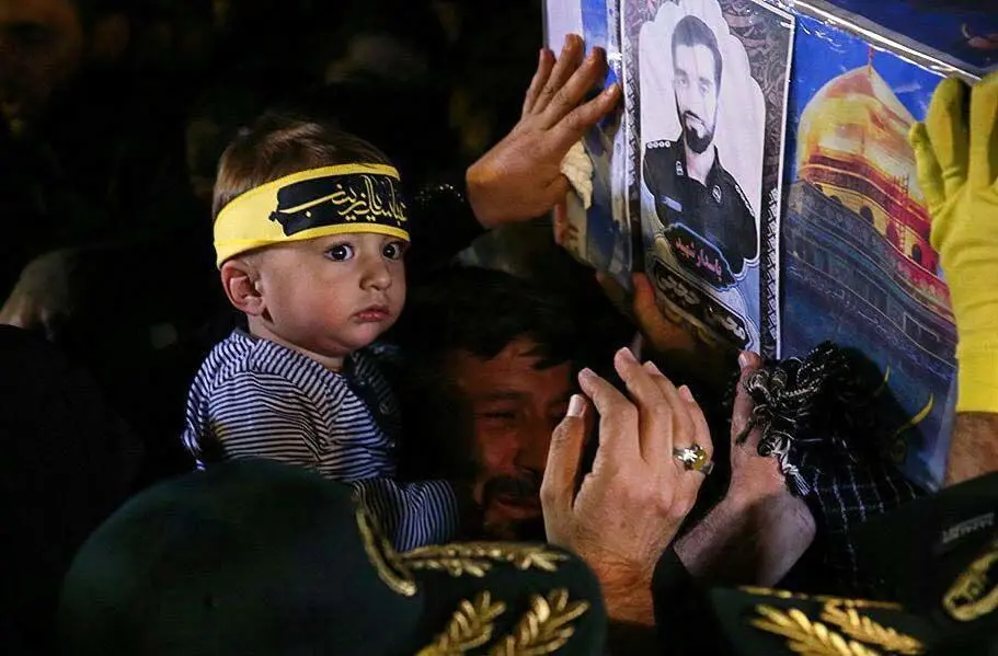 (تصاویر) فرزند شهید حججی مقابل تابوت پدر