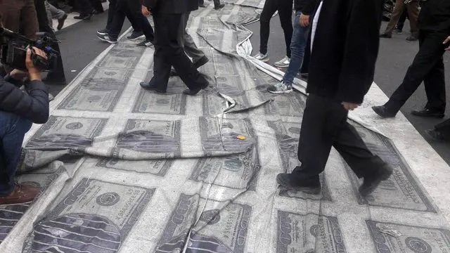 (تصویر) ۱۰۰ دلار‌های آمریکایی زیر پای راهپیمایی‌کنندگان
