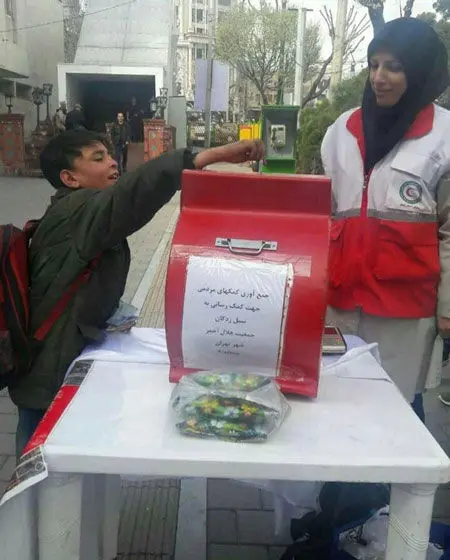 (عکس) دست یاری کودک کار تهرانی به سوی سیل‌زدگان