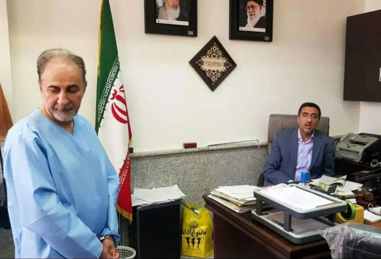 اولین عکس از نجفی با دست‌بند و لباس مخصوص تحت نظر