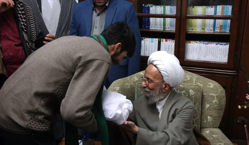 (تصاویر) اذان گفتن مصباح یزدی در گوش نوزاد