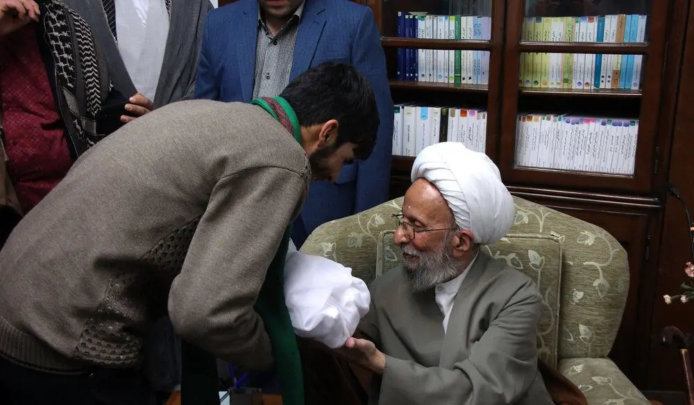 (تصاویر) اذان گفتن مصباح یزدی در گوش نوزاد