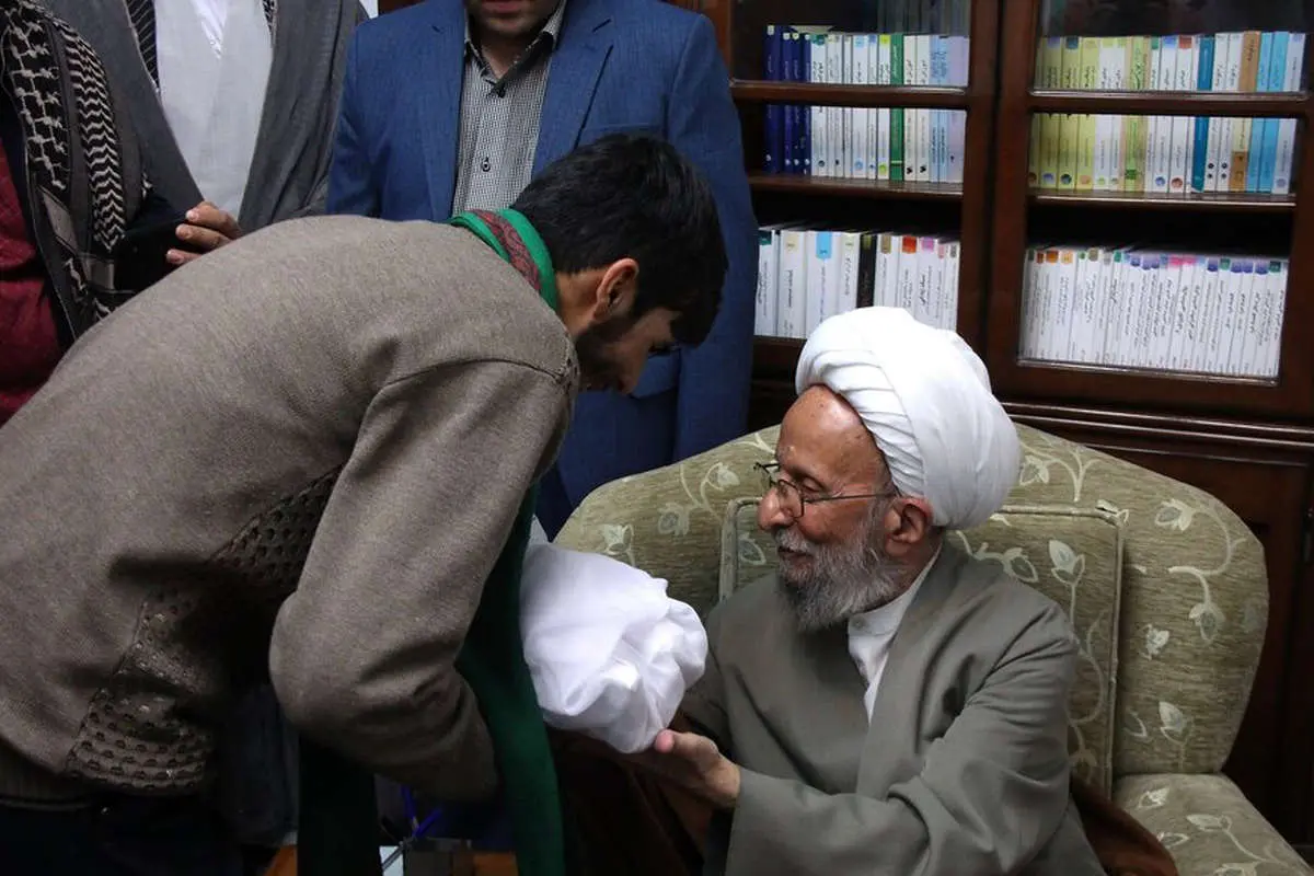 (تصاویر) اذان گفتن مصباح یزدی در گوش نوزاد