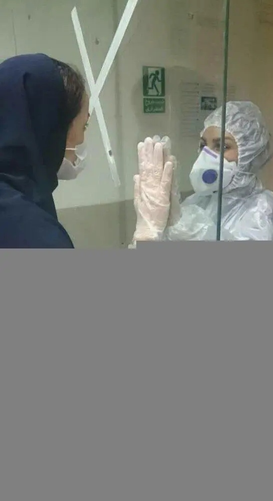 (عکس) تصویر تاثیرگذار از دو پرستار در مرز قرنطینه بیمارستان