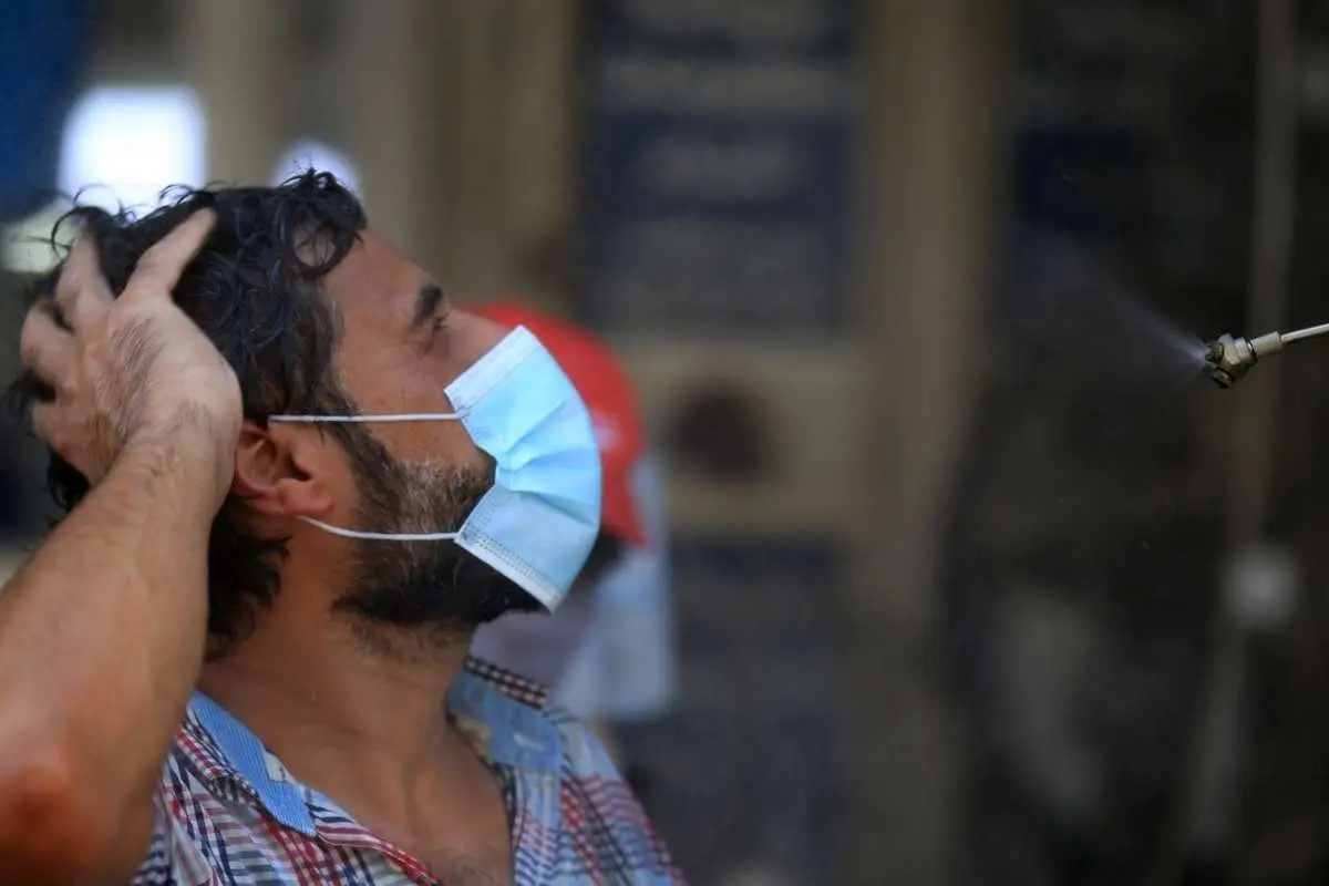 (تصاویر) دوشِ خیابانی برای مقابله با گرما در بغداد