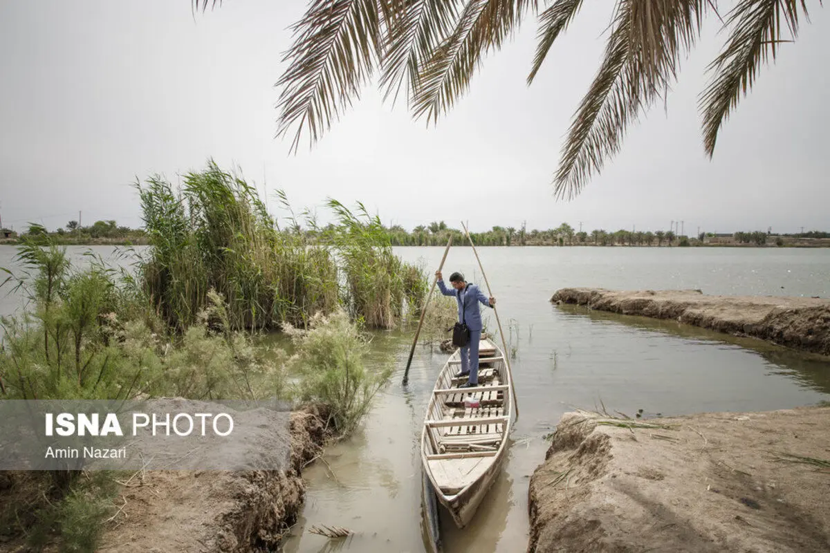 (تصاویر) رفتن معلم به مدرسه با قایق در خوزستان