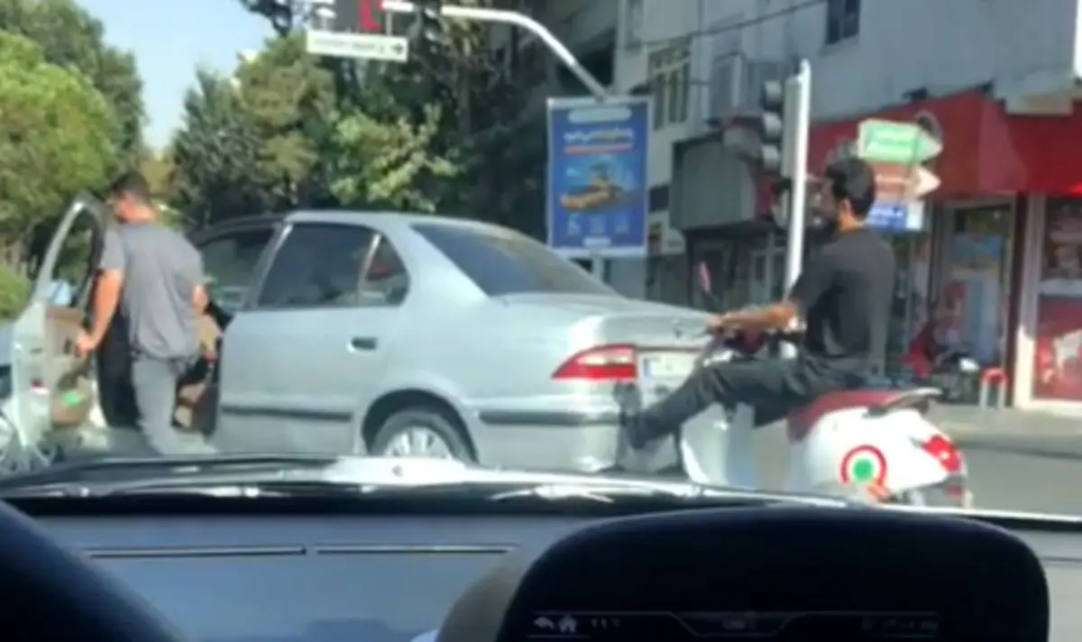 (ویدئو) اقدام عجیب راننده موتور؛ هل دادن سمند با پا در تهران