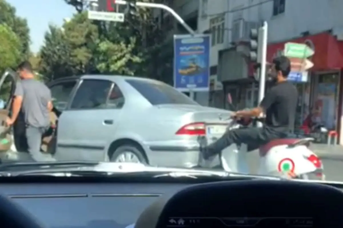 (ویدئو) اقدام عجیب راننده موتور؛ هل دادن سمند با پا در تهران