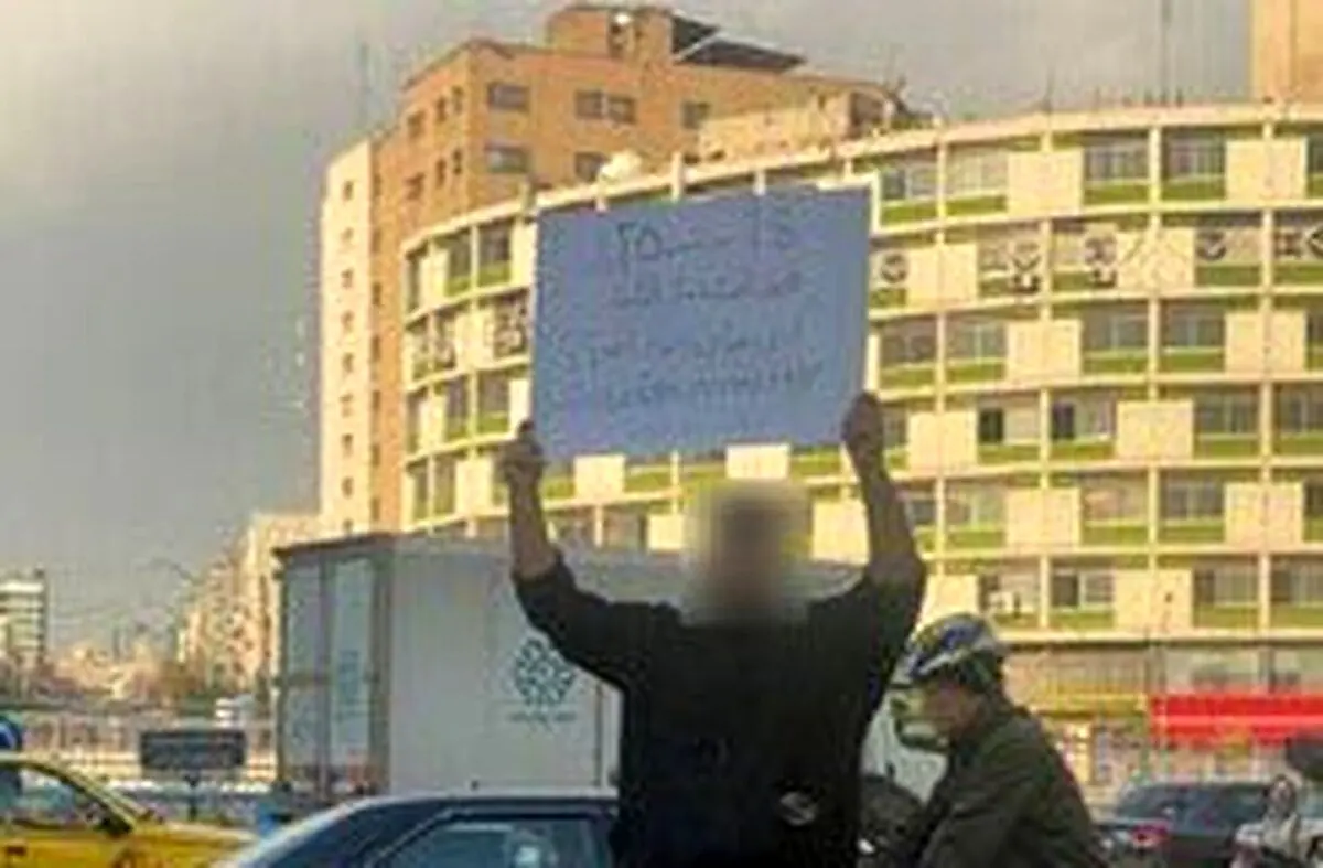 (تصویر) پلاکارد اعتراضی جوان ایرانی: مرده و زنده‌ی من برای کسی فرق می‌کنه؟!