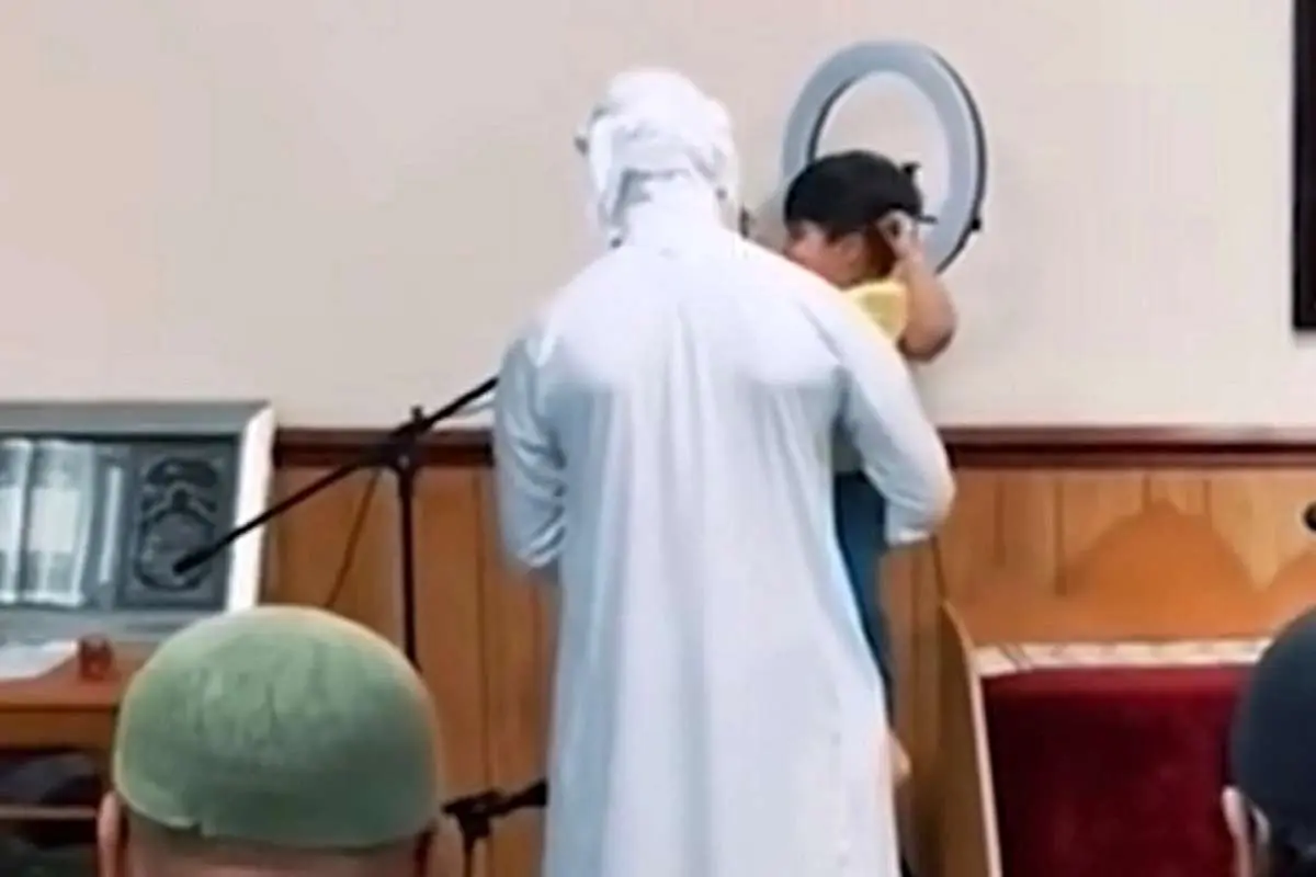 (ویدئو) یک کودک در آغوش امام جماعت درحال اقامه نماز
