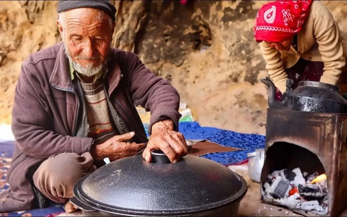 (ویدئو) پخت نان روی ساج و قابلی پلو با مرغ توسط زوج مسن غارنشین افغانستانی
