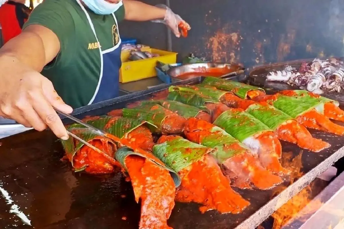 (ویدئو) غذای خیابانی مشهور در مالزی؛ کباب ماهی در برگ موز و ماهی مرکب سرخ شده