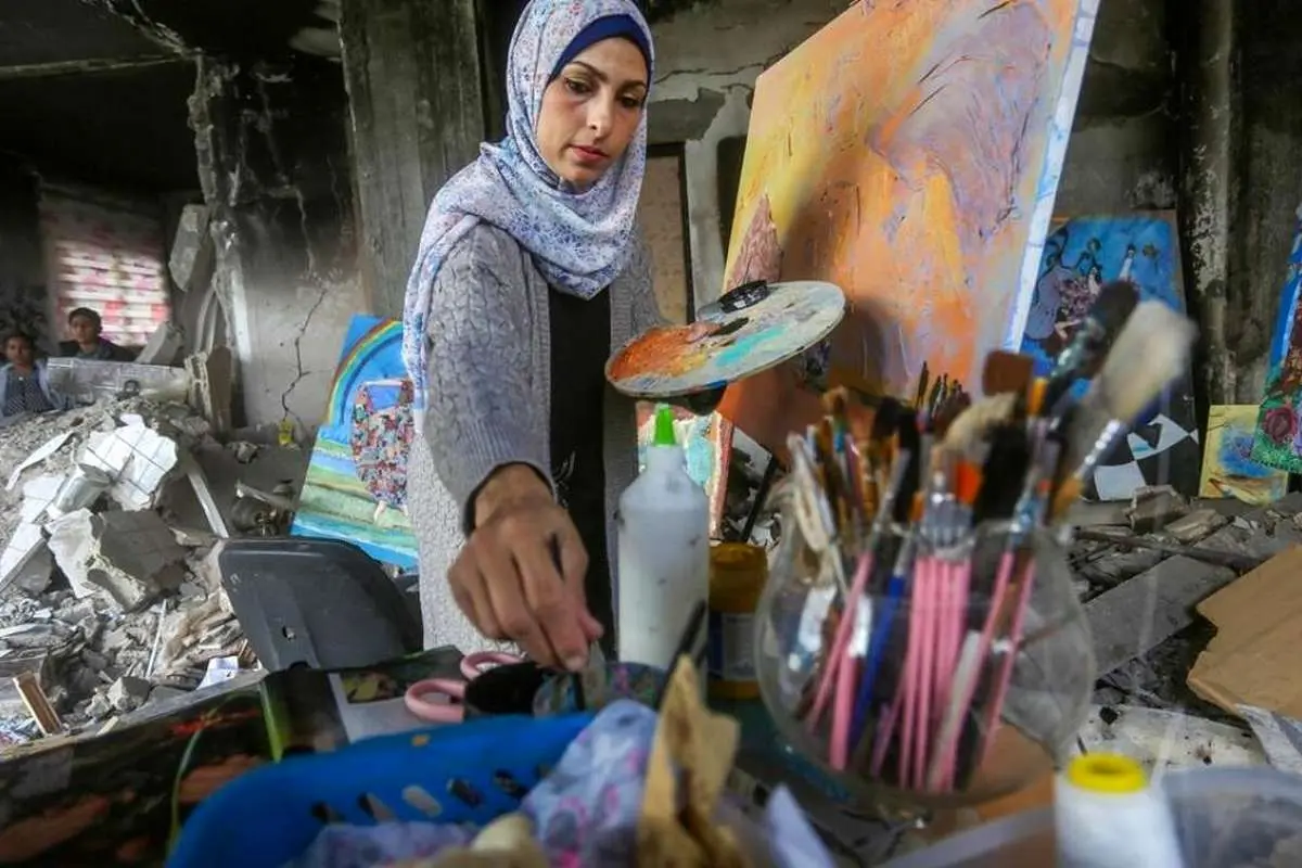 (تصاویر) نقاشی زن فلسطین در میان ویرانی