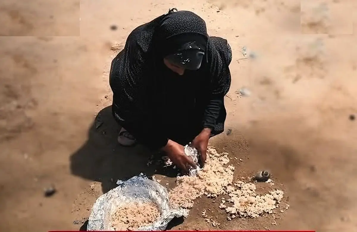 ببینید؛ زن فلسطینی در غزه باقی‌مانده‌های غذا را از زمین جمع می‌کند