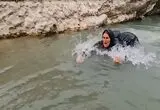 شیرجه زن بختیاری در آب برای شست‌وشوی گوسفندان