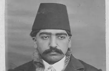 پسر ناصرالدین‌شاه نشسته روی زیرانداز در حیاط کاخ سلطنت‌آباد 