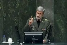 امیر حاتمی در حال نشانه‌گیری با مسلسل در کنار سپهبد باقری